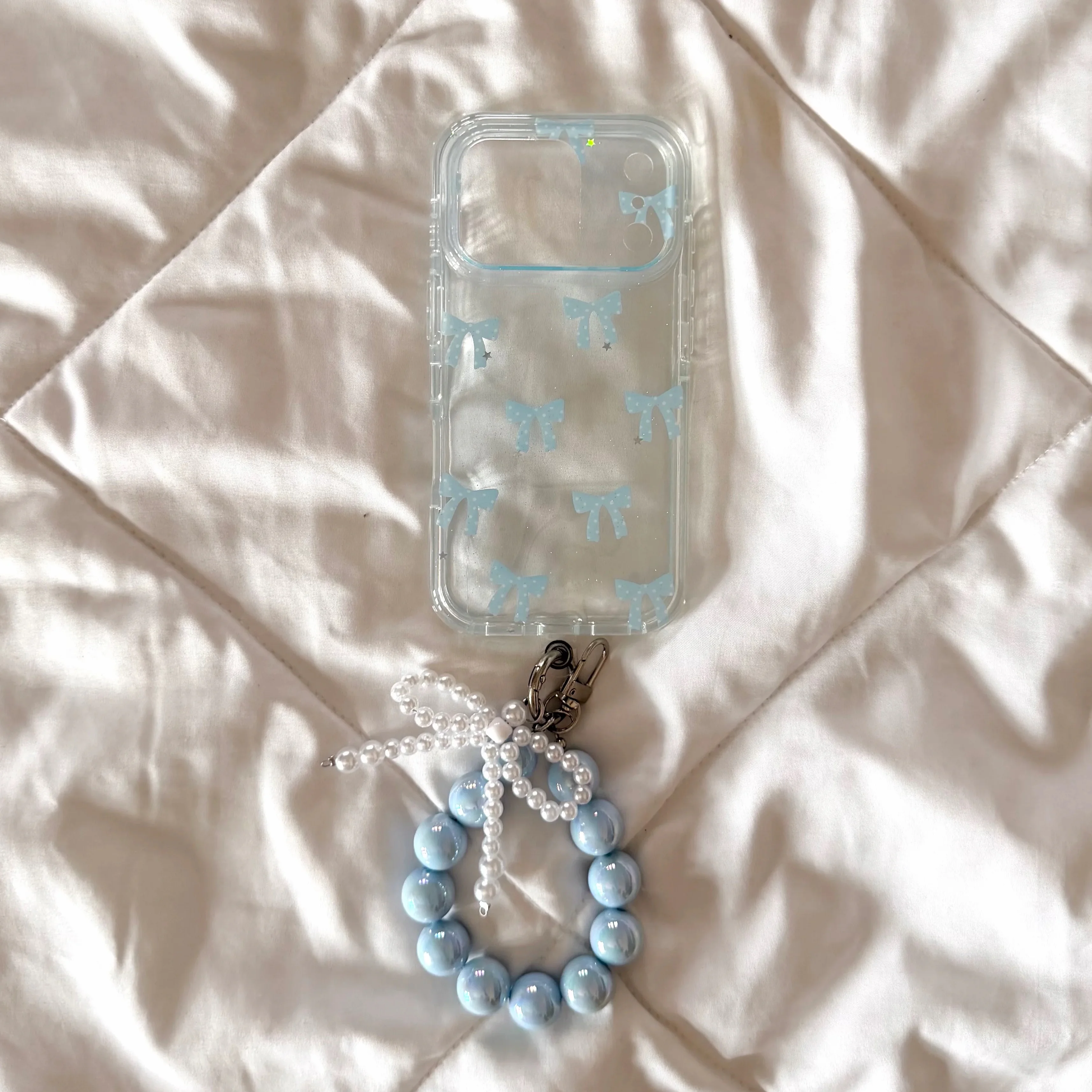 Blue bow case with beaded bracelet strap and bow charm
