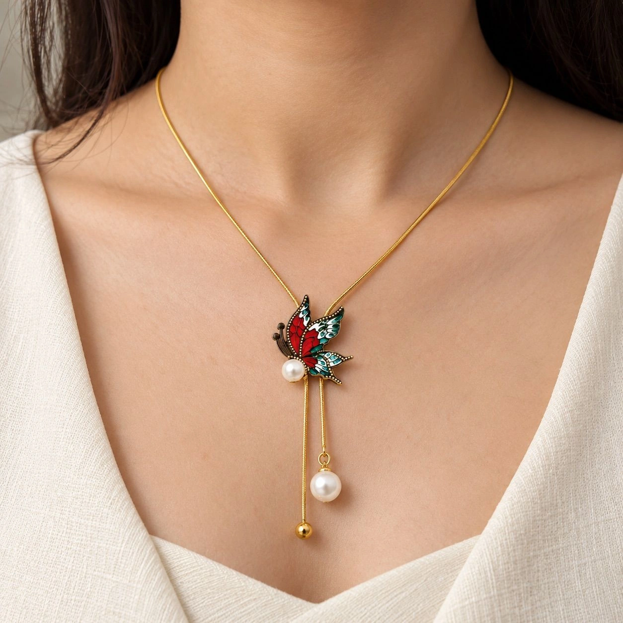 BUTTERFLY PENDANT NECKLACE ADORNED WITH FAUX PEARLS AND A TASSEL DROP 1