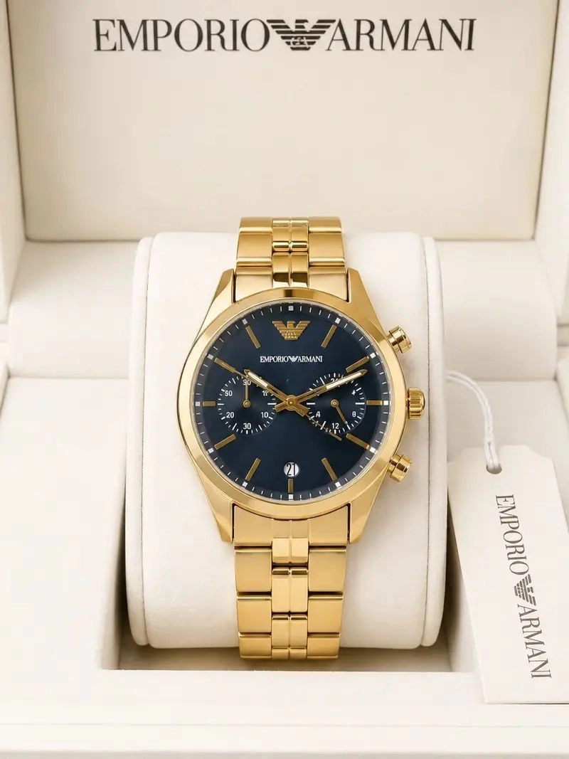 The Emporio Armani Gold Chronograph Watch blends modern sophistication with iconic fashion-inspired styling. Featuring a premium gold-tone stainless steel finish, elegant navy blue sunray dial, multi-function chronograph design, and reliable quartz movement, this timepiece is crafted for men who appreciate refined luxury and everyday elegance. 1