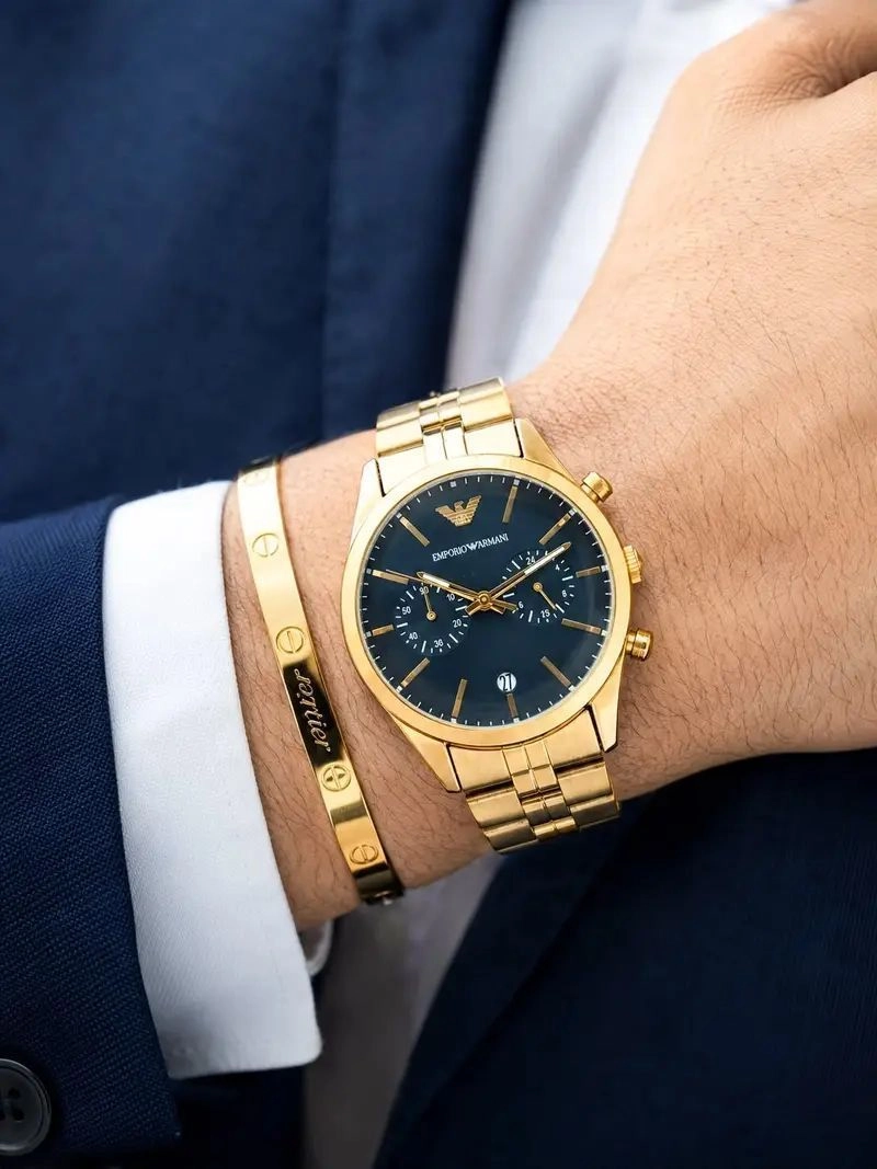 The Emporio Armani Gold Chronograph Watch blends modern sophistication with iconic fashion-inspired styling. Featuring a premium gold-tone stainless steel finish, elegant navy blue sunray dial, multi-function chronograph design, and reliable quartz movement, this timepiece is crafted for men who appreciate refined luxury and everyday elegance. 2