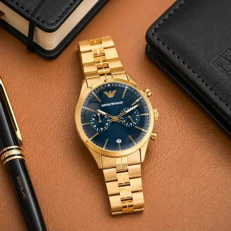 The Emporio Armani Gold Chronograph Watch blends modern sophistication with iconic fashion-inspired styling. Featuring a premium gold-tone stainless steel finish, elegant navy blue sunray dial, multi-function chronograph design, and reliable quartz movement, this timepiece is crafted for men who appreciate refined luxury and everyday elegance. 3